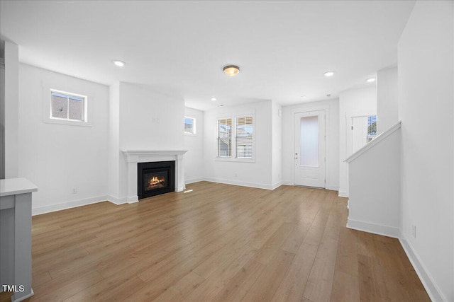 212 Aubey Ln, Wake Forest, NC 27587 - unfurnished living room featuring light wood finished floors, a lit fireplace, baseboards, and recessed lighting