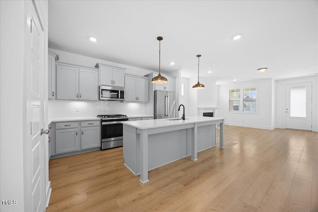 212 Aubey Ln, Wake Forest, NC 27587 - kitchen featuring appliances with stainless steel finishes, gray cabinetry, light wood finished floors, tasteful backsplash, and light countertops