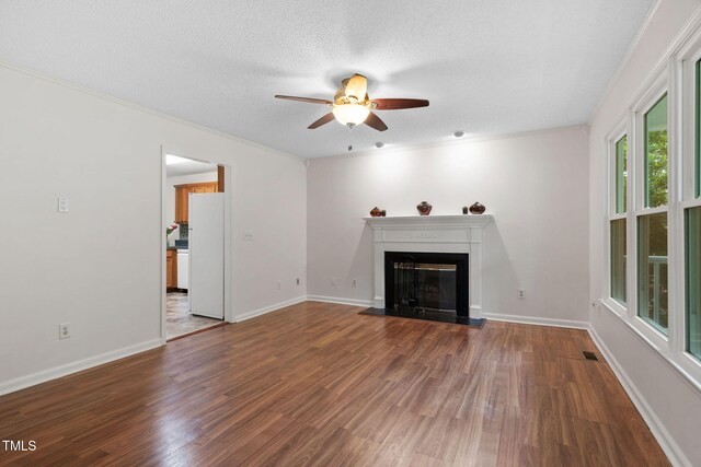 2724 Glastonbury Rd, Apex, NC 27539 - unfurnished living room featuring a ceiling fan, a glass covered fireplace, wood finished floors, baseboards, and a textured ceiling