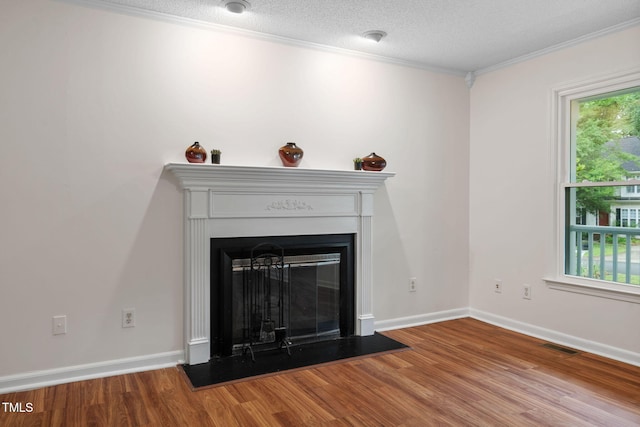 2724 Glastonbury Rd, Apex, NC 27539 - detailed view of wood finished floors, crown molding, a glass covered fireplace, and baseboards