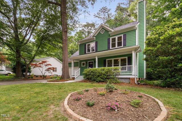 2724 Glastonbury Rd, Apex, NC 27539 - view of front of house featuring covered porch, a chimney, a front lawn, and driveway