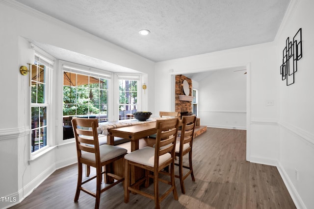 7832 Shuttle Rd, Fayetteville, NC 28311 - dining area with a textured ceiling, wood finished floors, ornamental molding, and a fireplace