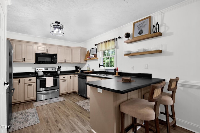 7832 Shuttle Rd, Fayetteville, NC 28311 - kitchen with stainless steel appliances, a peninsula, a textured ceiling, dark countertops, and light wood-style floors