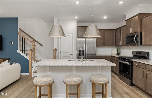 4028 Kidd Pl, Durham, NC 27703 - kitchen with appliances with stainless steel finishes, a sink, light wood-style floors, tasteful backsplash, and recessed lighting