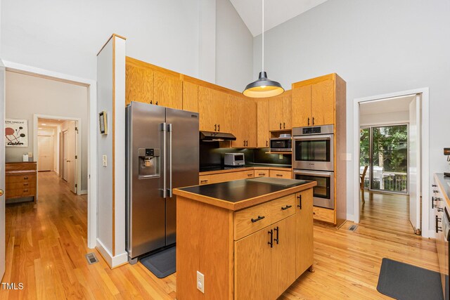 6 Womble Cir, Durham, NC 27705 - kitchen with stainless steel appliances, high vaulted ceiling, under cabinet range hood, a center island, and light wood-style floors