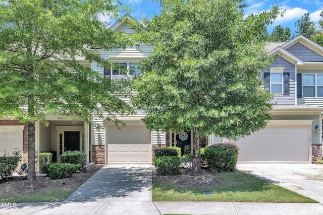 342 Westgrove Ct, Durham, NC 27703 - obstructed view of property with stone siding, driveway, and a garage