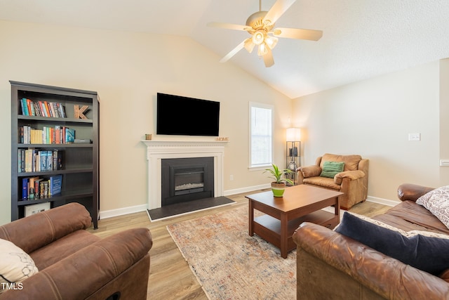 358 Tillamook Dr, Wake Forest, NC 27587 - living area featuring ceiling fan, light wood-style floors, vaulted ceiling, a glass covered fireplace, and baseboards