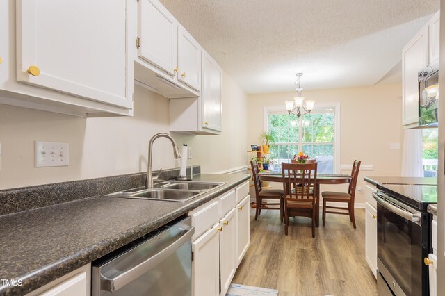 358 Tillamook Dr, Wake Forest, NC 27587 - kitchen featuring appliances with stainless steel finishes, a sink, light wood-style flooring, white cabinetry, and a textured ceiling