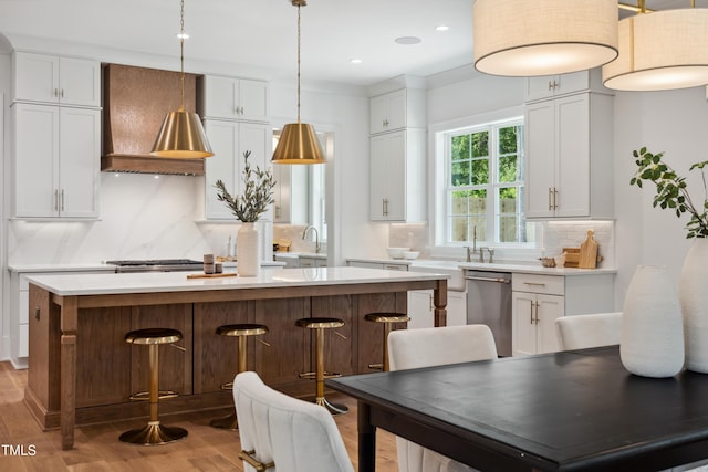 217 Dublin Rd, Raleigh, NC 27609 - kitchen with stainless steel appliances, light wood finished floors, white cabinets, custom exhaust hood, and backsplash