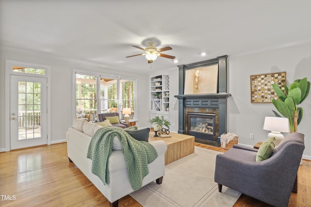 314 Chanticlair Dr, Apex, NC 27502 - living area with a fireplace with flush hearth, crown molding, plenty of natural light, light wood finished floors, and a ceiling fan