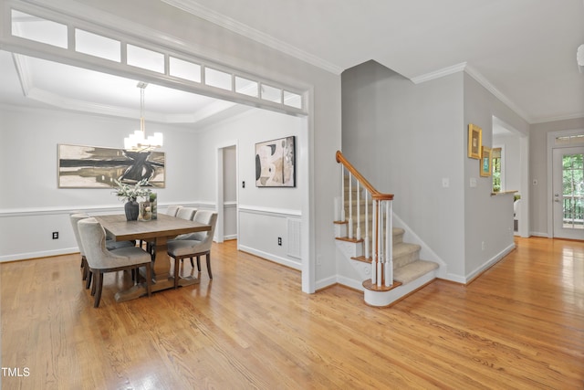 314 Chanticlair Dr, Apex, NC 27502 - dining room with light wood-type flooring, stairway, a chandelier, and crown molding