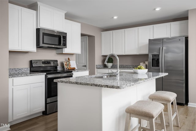 616 Impala, Wendell, NC 27591 - kitchen featuring appliances with stainless steel finishes, a sink, light wood-style floors, white cabinets, and recessed lighting
