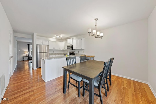 72 Justin Ct, Durham, NC 27705 - dining room featuring light wood-style flooring, a chandelier, and baseboards