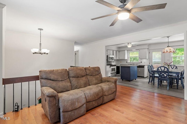 105 Otter Dr, Cary, NC 27513 - living room with a chandelier, light wood-style flooring, crown molding, and a ceiling fan