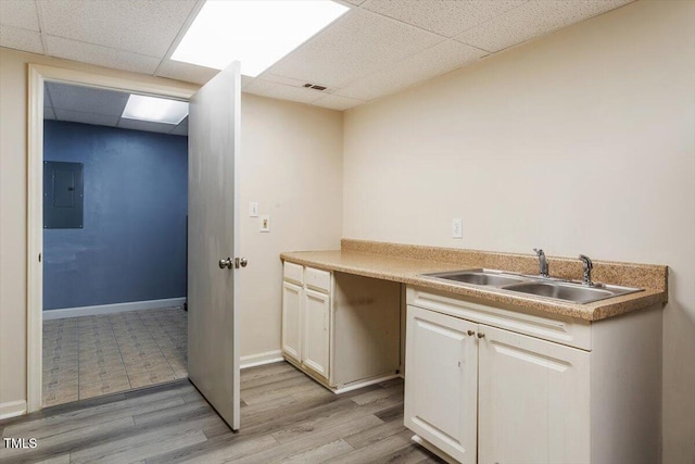 105 Otter Dr, Cary, NC 27513 - kitchen with electric panel, a paneled ceiling, white cabinetry, and light wood-style floors
