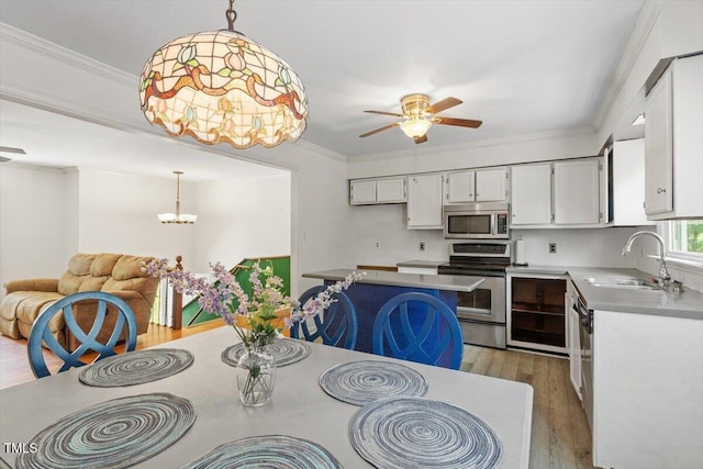 105 Otter Dr, Cary, NC 27513 - dining space featuring a ceiling fan, light wood-style floors, a chandelier, and crown molding