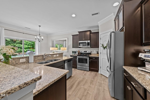 205 Willow Weald Ct, Fuquay Varina, NC 27526 - kitchen with stainless steel appliances, a sink, ornamental molding, a chandelier, and dark brown cabinetry