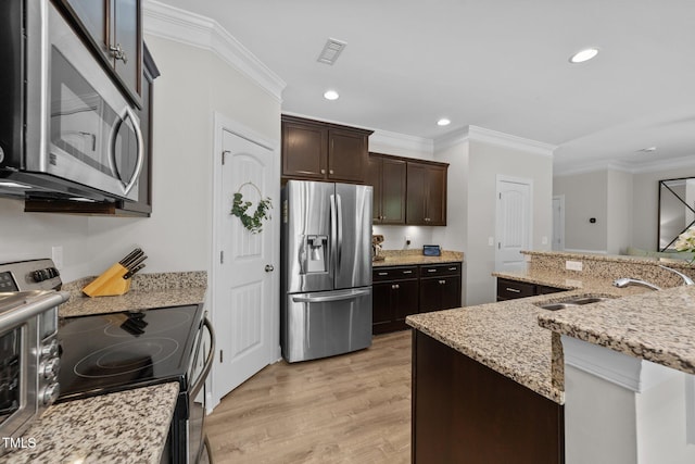 205 Willow Weald Ct, Fuquay Varina, NC 27526 - kitchen featuring stainless steel appliances, crown molding, a sink, light wood-style flooring, and dark brown cabinetry