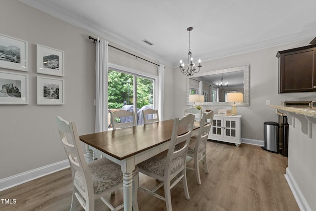 205 Willow Weald Ct, Fuquay Varina, NC 27526 - dining area with a chandelier, ornamental molding, wood finished floors, and baseboards