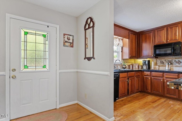 3298 Oakridge Dr Unit A, Graham, NC 27253 - kitchen featuring black appliances, a sink, light wood-type flooring, dark countertops, and backsplash
