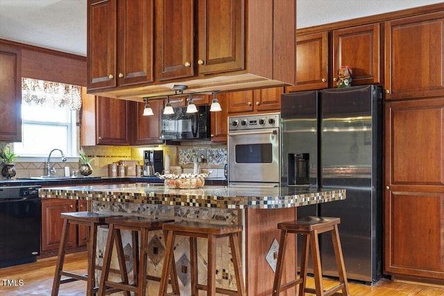 3298 Oakridge Dr Unit A, Graham, NC 27253 - kitchen featuring black appliances, a sink, a breakfast bar area, light wood finished floors, and backsplash
