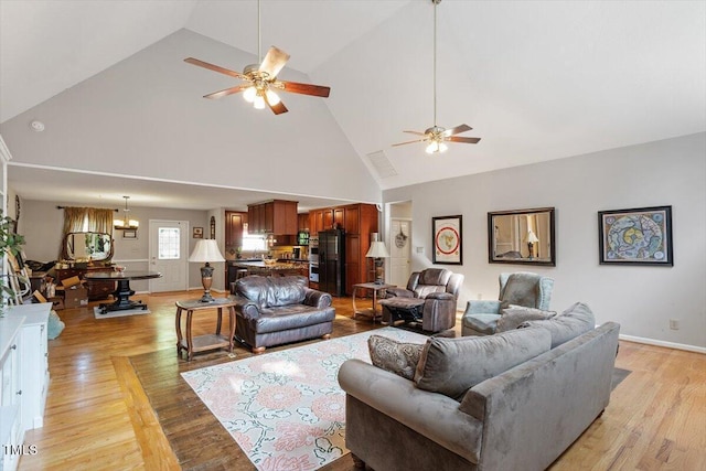 3298 Oakridge Dr Unit A, Graham, NC 27253 - living area featuring ceiling fan, high vaulted ceiling, a chandelier, light wood-style floors, and baseboards