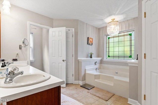 3298 Oakridge Dr Unit A, Graham, NC 27253 - bathroom featuring a garden tub, double vanity, a chandelier, and a textured ceiling