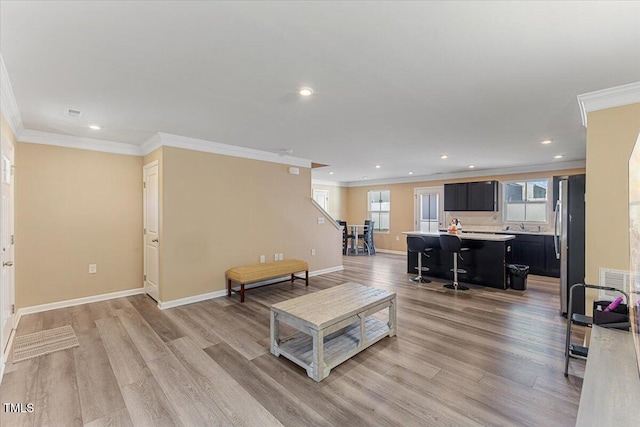 1004 Bridgewater Dr, Durham, NC 27704 - living area featuring ornamental molding, light wood-style floors, recessed lighting, and baseboards
