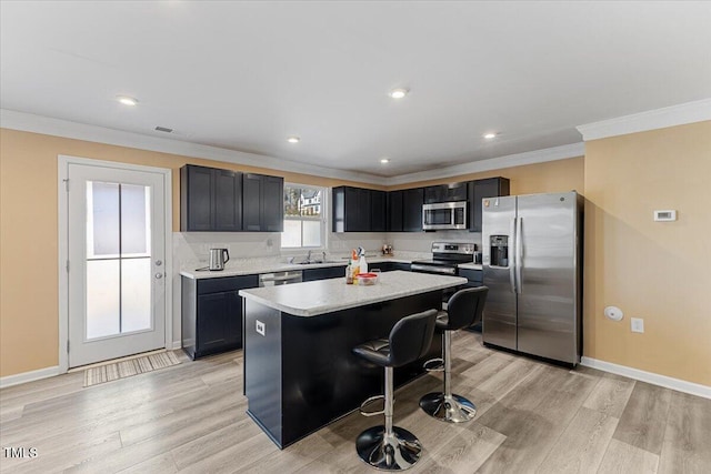 1004 Bridgewater Dr, Durham, NC 27704 - kitchen featuring stainless steel appliances, a center island, light countertops, ornamental molding, and a breakfast bar area