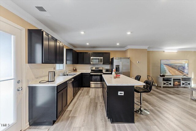 1004 Bridgewater Dr, Durham, NC 27704 - kitchen featuring stainless steel appliances, a kitchen breakfast bar, a sink, a kitchen island, and dark cabinets