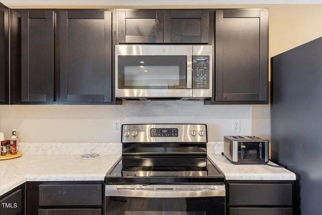 1004 Bridgewater Dr, Durham, NC 27704 - kitchen with appliances with stainless steel finishes, light countertops, and dark brown cabinetry