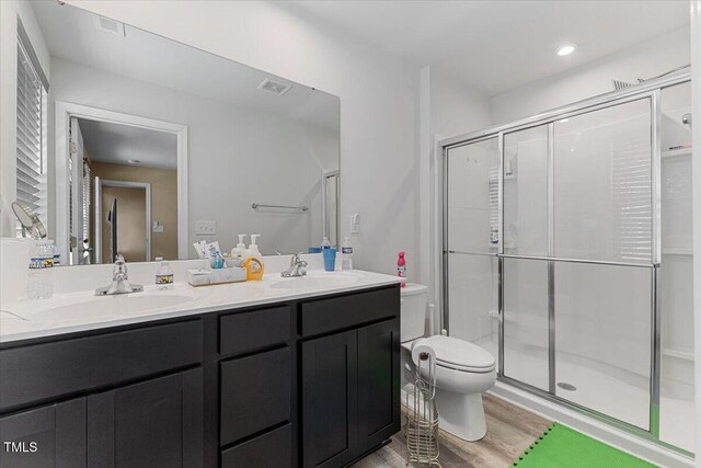 1004 Bridgewater Dr, Durham, NC 27704 - full bath with double vanity, toilet, wood finished floors, and a shower stall