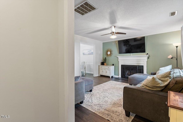 1 Old Towne Pl, Durham, NC 27713 - living room with ceiling fan, crown molding, a fireplace, dark wood-style floors, and a textured ceiling