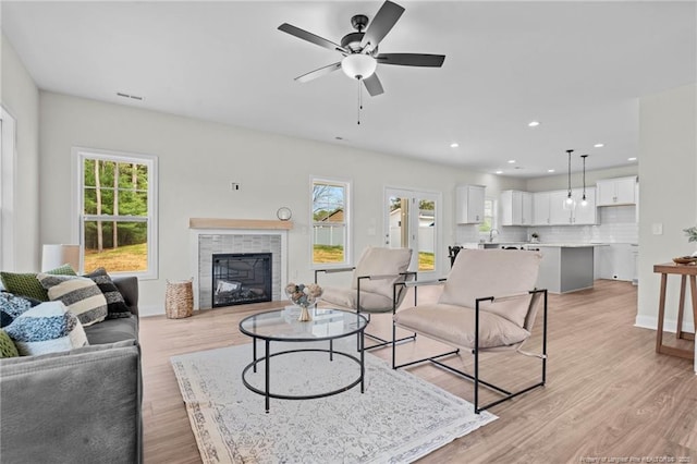 60 Bennett Rd, Coats, NC 27521 - living area with plenty of natural light, a tiled fireplace, ceiling fan, light wood-style flooring, and recessed lighting