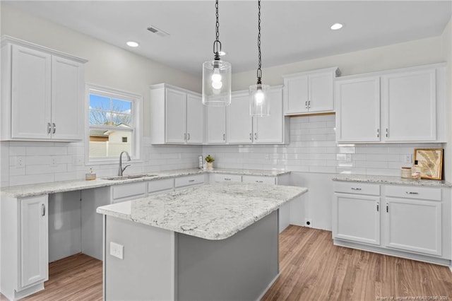 60 Bennett Rd, Coats, NC 27521 - kitchen with a sink, light wood-style flooring, white cabinets, decorative backsplash, and recessed lighting