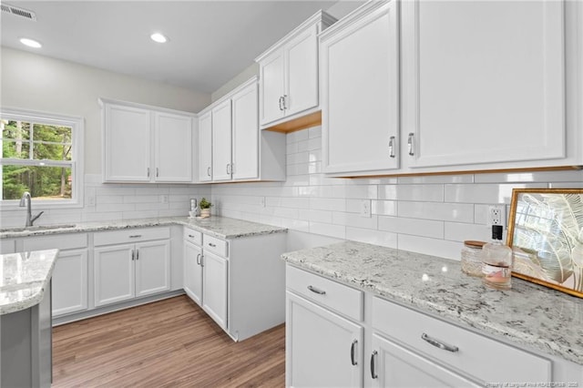 60 Bennett Rd, Coats, NC 27521 - kitchen with a sink, light stone counters, white cabinets, decorative backsplash, and recessed lighting