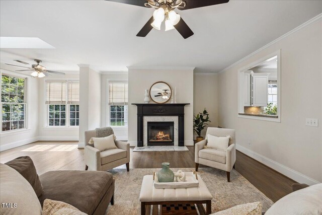 2725 Rosedale Ave, Raleigh, NC 27607 - living room with a ceiling fan, baseboards, ornamental molding, a high end fireplace, and wood finished floors