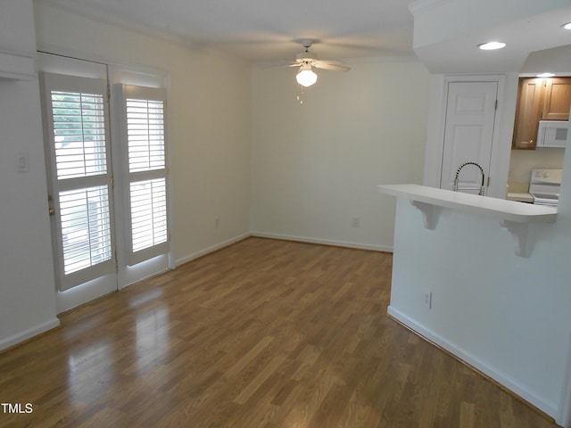 1402 Barton Place Dr, Raleigh, NC 27608 - kitchen featuring white microwave, stove, a kitchen breakfast bar, ceiling fan, and light countertops