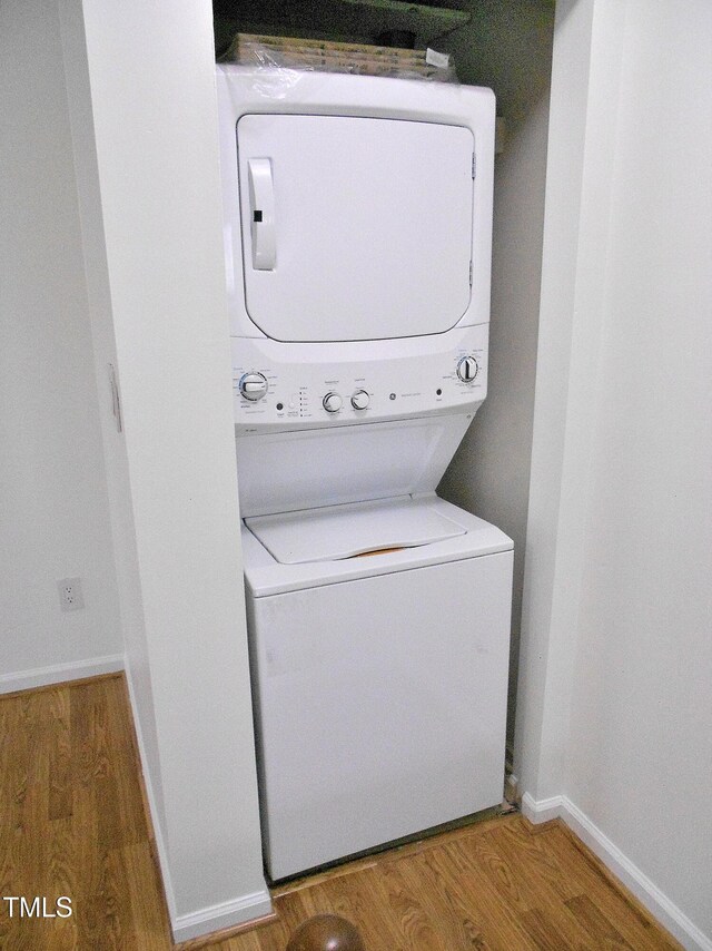 1402 Barton Place Dr, Raleigh, NC 27608 - laundry room with stacked washer and clothes dryer, wood finished floors, and baseboards