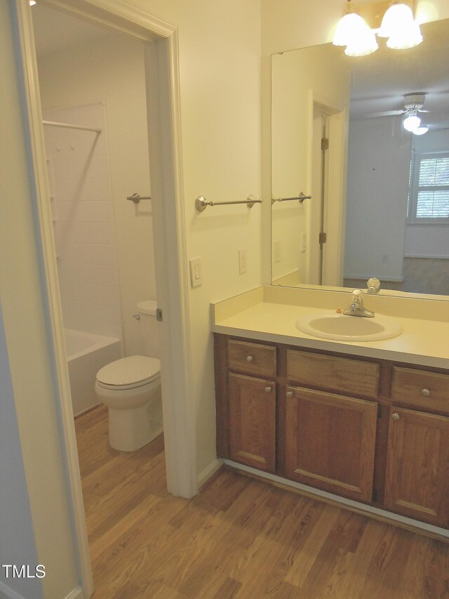 1402 Barton Place Dr, Raleigh, NC 27608 - full bath featuring wood finished floors, vanity, toilet, and washtub / shower combination