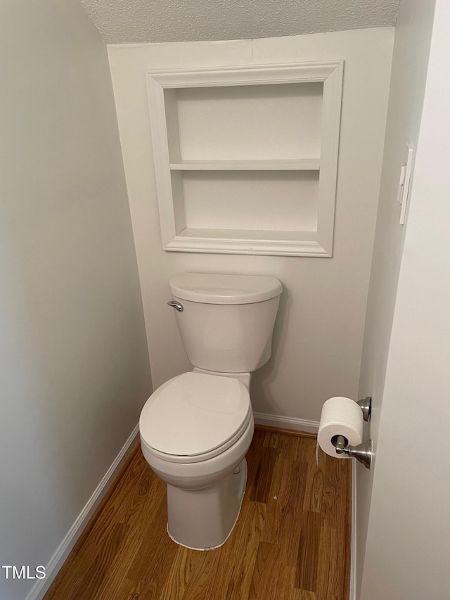 1402 Barton Place Dr, Raleigh, NC 27608 - bathroom featuring wood finished floors, toilet, baseboards, and a textured ceiling