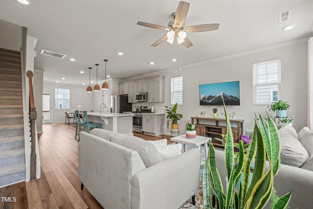 5430 Crescent Square St, Raleigh, NC 27616 - living area featuring stairway, ornamental molding, healthy amount of natural light, wood finished floors, and recessed lighting
