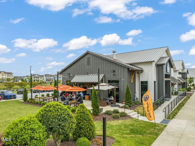 5430 Crescent Square St, Raleigh, NC 27616 - view of side of home with a residential view, a standing seam roof, a lawn, metal roof, and board and batten siding
