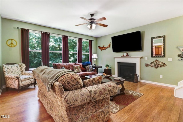 1304 Double Oak Ln, Willow Springs, NC 27592 - living room featuring ceiling fan, wood finished floors, a fireplace with flush hearth, and baseboards