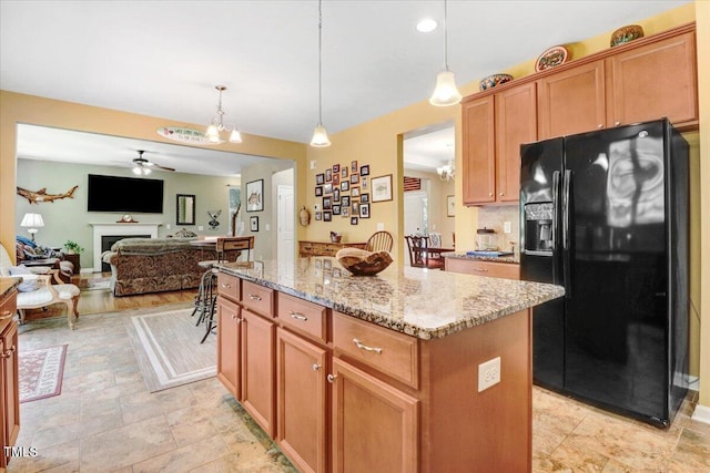 1304 Double Oak Ln, Willow Springs, NC 27592 - kitchen with black fridge, light stone counters, a ceiling fan, a kitchen island, and open floor plan