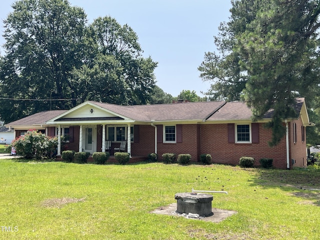 2433 Zacks Mill Rd, Angier, NC 27501 - single story home with an outdoor fire pit, a porch, brick siding, and a front lawn