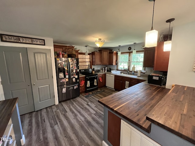 2433 Zacks Mill Rd, Angier, NC 27501 - kitchen featuring black appliances, wood counters, a peninsula, dark wood-type flooring, and hanging light fixtures