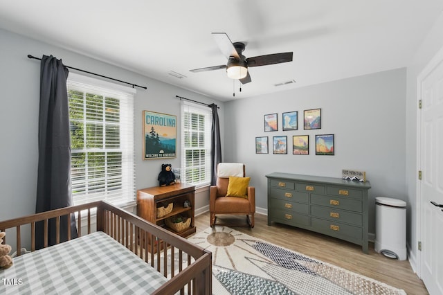 2933 Creek Moss Ave, Wake Forest, NC 27587 - bedroom featuring light wood-type flooring, a nursery area, and ceiling fan