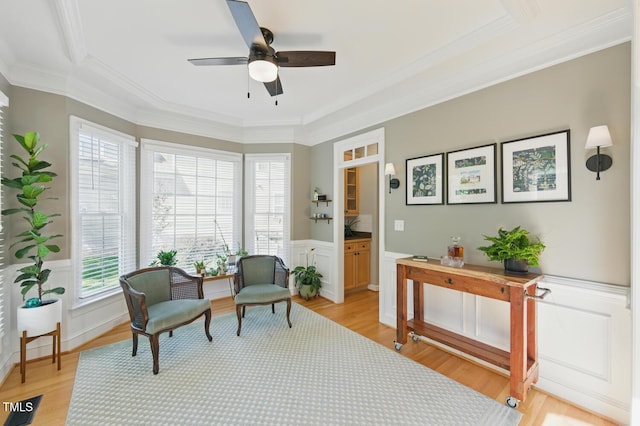 2933 Creek Moss Ave, Wake Forest, NC 27587 - living area with crown molding, a ceiling fan, light wood-style flooring, wainscoting, and a decorative wall