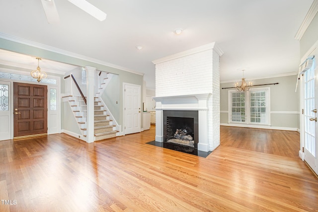 7605 Sandy Lake Ct, Raleigh, NC 27613 - unfurnished living room with a chandelier, stairs, wood finished floors, a fireplace, and ornamental molding